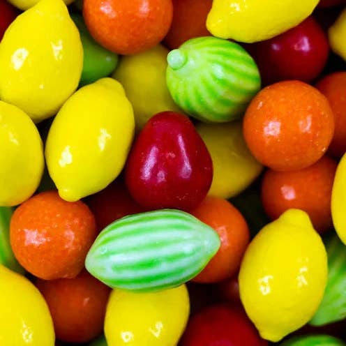 Assorted colorful candies including lemons, oranges, and green striped candies.
