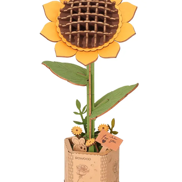 A completed 3D wooden puzzle in the shape of a sunflower with yellow petals and a brown center, assembled from pieces with a grid pattern.