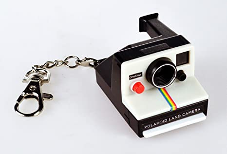 A miniature toy camera resembling a Polaroid, with black, white, and multicolor details, a chain attached to it, and a simulated film window.