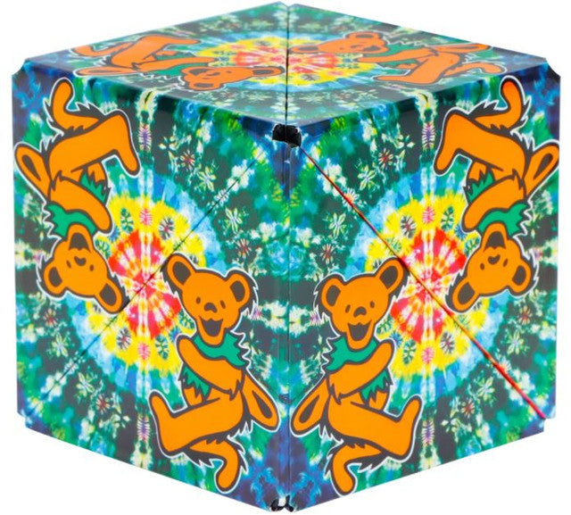 A multicolored geometric puzzle cube with orange bears on a tie-dye pattern background.