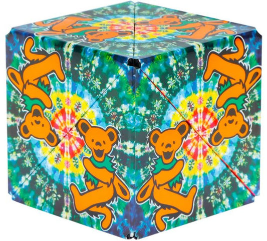 A multicolored geometric puzzle cube with orange bears on a tie-dye pattern background.