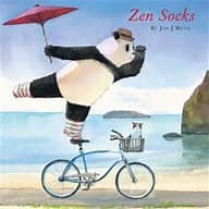 A book cover for 'Zen Socks' featuring an illustration of a panda in a hat holding an umbrella, with a bicycle and a cat in the background, set against a beach and ocean background.